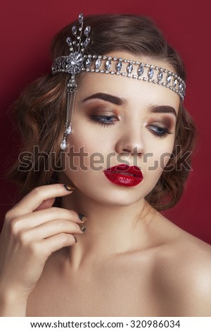 Retro portrait of a beautiful woman on a red Background.. Vintage style. Fashion Beauty photo. woman with curly hair and evening make-up. Jewelry and Beauty. Red lips. Picture taken in the studio
