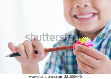 Smiling boy use a pencil sharpener and Rainbow pencil  shaving ,Creative concept, 