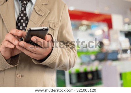 Man in shopping mall using mobile phone.
