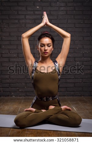 Beautiful Girl Doing Yoga Exercises On Brick Wall Background
