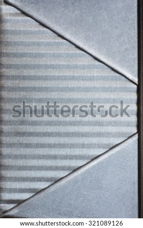 Closeup of galvanized steel metal on side of a meatloaf baking pan as a textured background in gray, silver metallic tones with room or space for copy, text, your words.  Vertical modern look