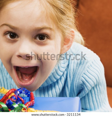 Caucasian girl with excited expression looking at viewer.