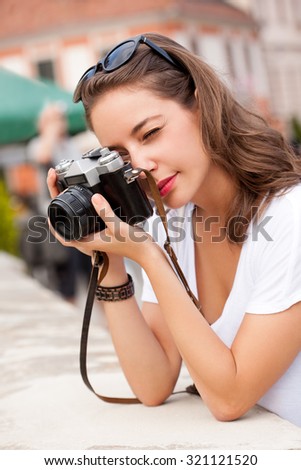 Portrait of a young brunette tourist woman taking photo.