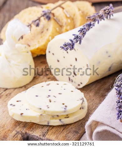 Meat loaf of fresh homemade butter with lavender on a wooden background. Top view. Horizontal. The concept of natural organic food. Selective Focus