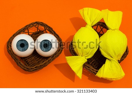 Halloween. funny scene with two eyeballs and other two wrapped as candy. halloween theme.
