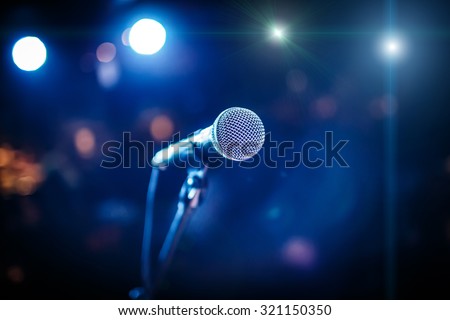 Microphone on stage against a background of auditorium Royalty-Free Stock Photo #321150350