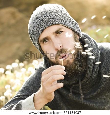 Portrait of a young man with a dandelion in his hand / Dandelion 
