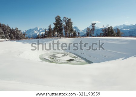 Winter landscape with high mountains and green forest in Arkhyz