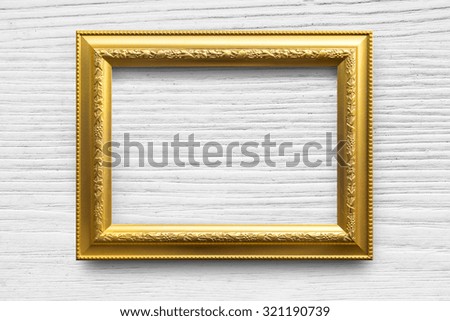 Antique golden frame on white wood background.