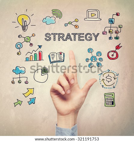 Hand pointing to Strategy concept on light brown wall background