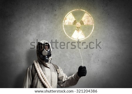 Man in respirator with radioactivity balloon in hands