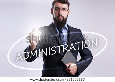 Businessman writing "Administration" with marker on transparent board.