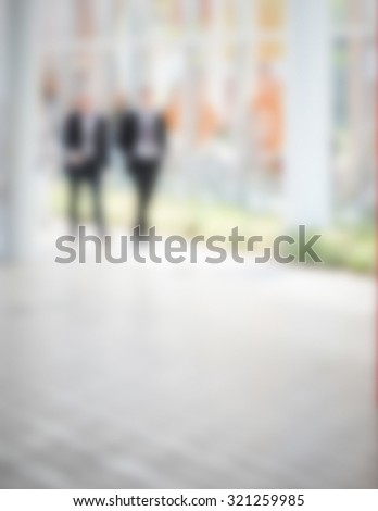 Couple of men walking, generic background. Intentionally blurred post production.