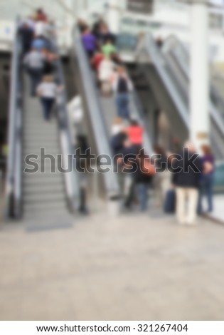 People on escalators, generic background, intentionally blurred post production.