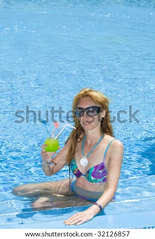 Attractive woman sits with glass of cocktail in ditch