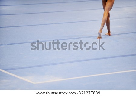Feet of gymnast are seen on the floor exercise during gymnastics competition