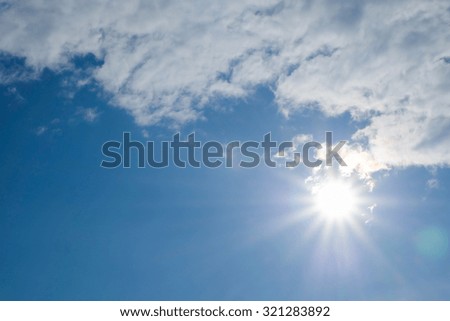 sun on blue sky with cloud, image with flare effect from lens