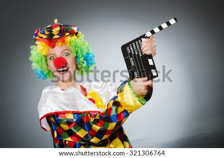 Clown with movie clapper in funny concept
