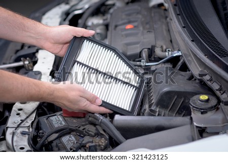 Replacing an air filter in a car Royalty-Free Stock Photo #321423125