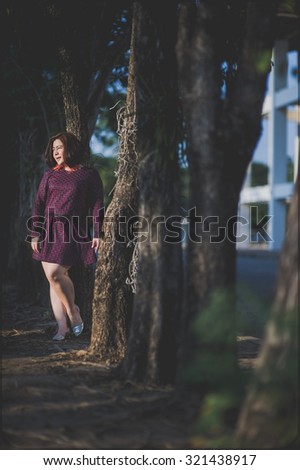 asia fat woman in purple dress with tree background