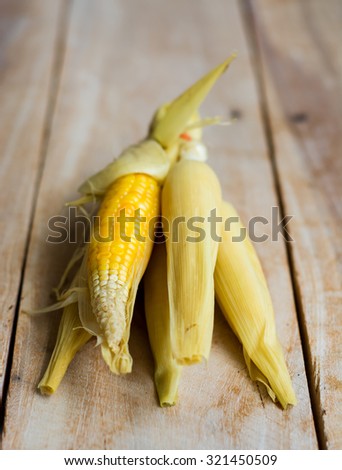 Baby sweet corn on wooden background
