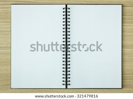 open spiral notebook on wood background