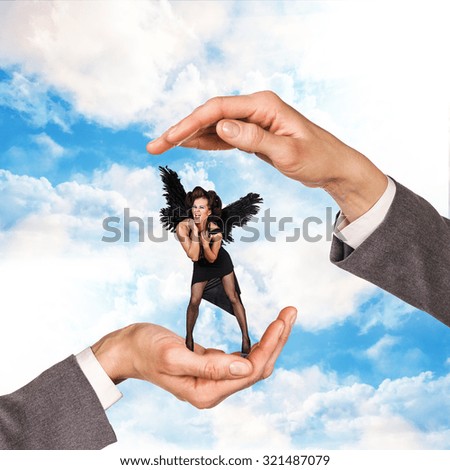 Hands holding woman between palms over sky background