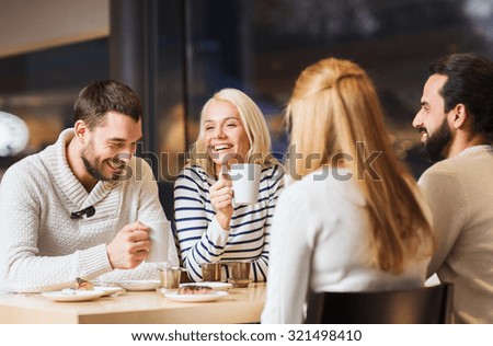 people, leisure and communication concept - happy friends meeting and drinking tea or coffee at cafe Royalty-Free Stock Photo #321498410