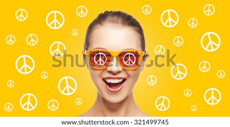 people, summer accessories and pop art concept - happy screaming teenage hippy girl in shades over yellow background with peace signs