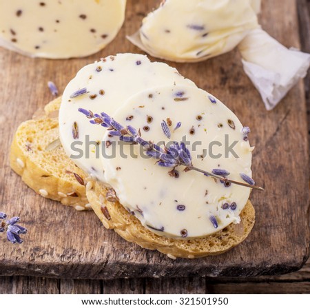 Homemade fresh butter with lavender flowers in parchment on the wooden background. The concept of natural organic food. selective Focus