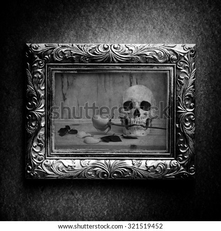 Vintage photo frame, photo of skull with rose over grunge background, halloween concept, black and white 