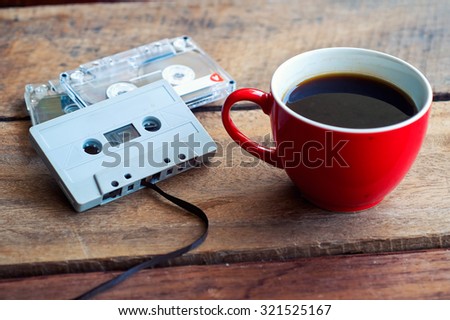 Cassette tape over and coffee cup on wooden table vintage effect