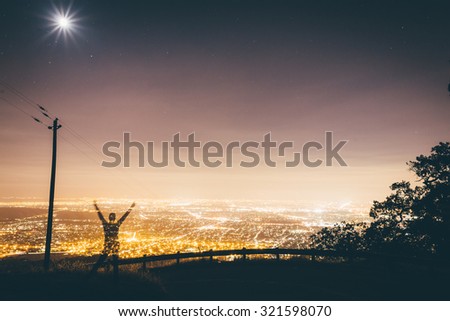 Young person looking over the city at night