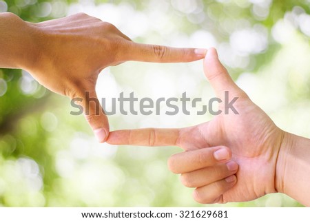 Photo sight:Frame made of hands with blur,bokeh tree Background