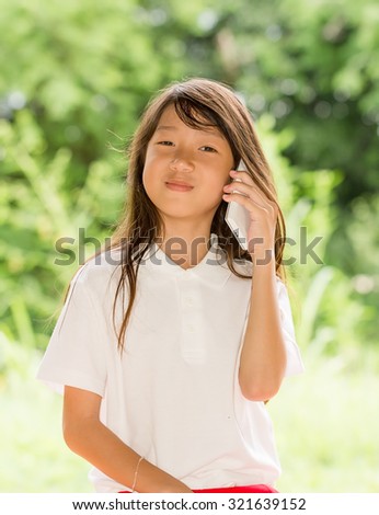 Asia girl use smart phone in garden at summer outdoor