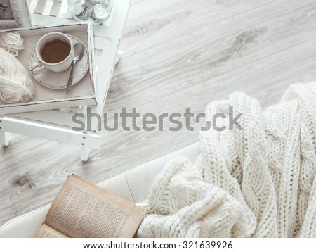 Still life details, cup of tea on retro vintage wooden tray on a coffee table in living room, top view point. Lazy winter weekend with a book on the sofa. Royalty-Free Stock Photo #321639926