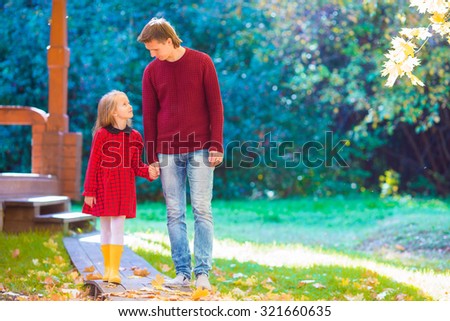 Young father with little daughter in autumn park outdoors