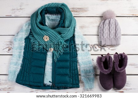 Winter women's clothing. Women's warm set of clothing on a wooden background. Trendy look.