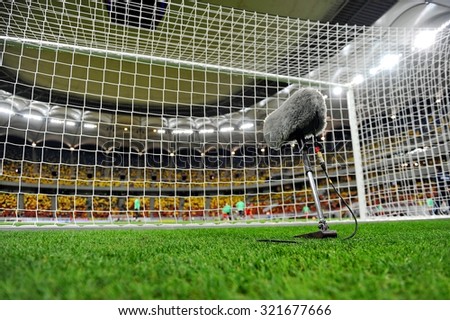 Big and furry sport microphone on a soccer field behind the goal net