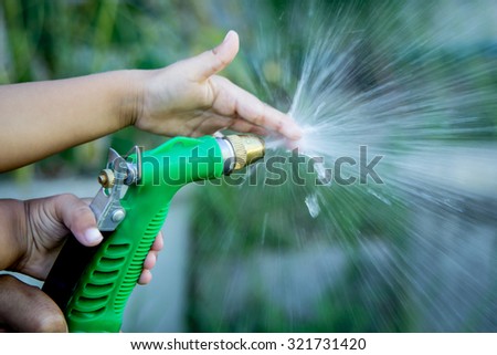 Father and child hand help watering plant in garden,selective focus