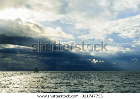 The boat in the mid of the ocean when storm are coming.
