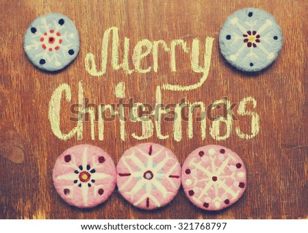 Merry Christmas note and decorative ornaments on wood background
