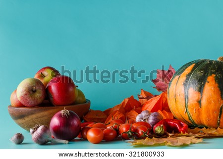 Colored pumpkin, apples and fall harvest on aquamarine shadowless background