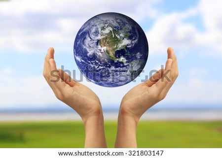 Hand holding the blue Earth. Elements of this image furnished by NASA