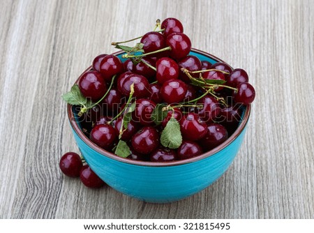 Fresh ripe Cherry in the bowl on wood background