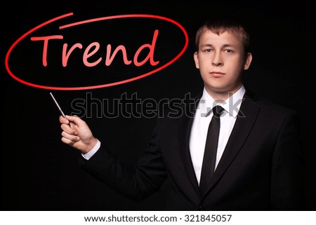 Man Hand specify, writing Trend with Red Pen on visual black screen. Isolated on black. Business, technology, internet concept.