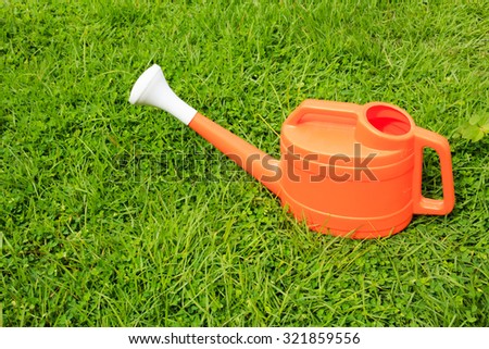 Watering can on grass.