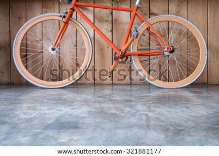 fixed gear bicycle parked with wood wall, close up image part of bicycle
