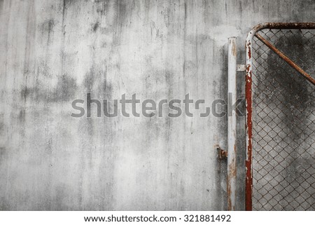 cement wall background with rusty iron chain wire fence