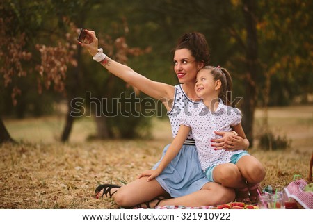 Mother and daughter taking selfie in nature